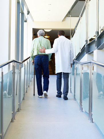 高齢者の歩行を介助する医師