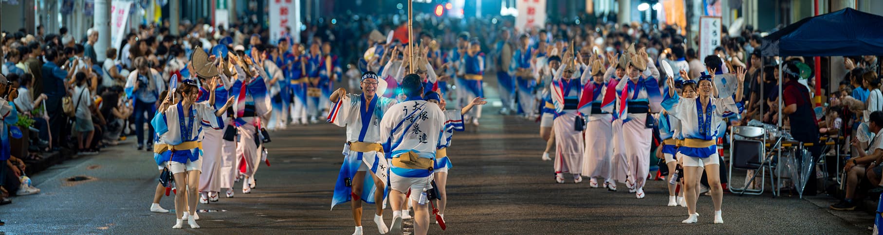 夜の街を踊り歩く阿波踊りの祭りの様子
