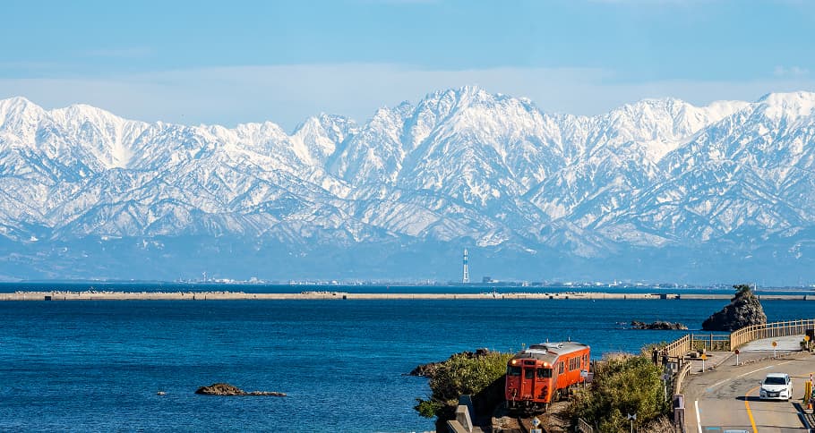 雪山を背景に走る赤い列車