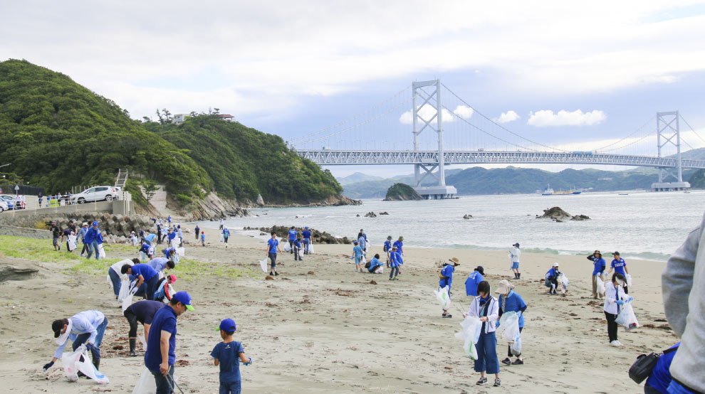 海ごみゼロウィークに実施された海岸清掃活動に参加する社員とその家族